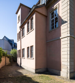 Schloss und Schlossgarten Schwetzingen - Garten - Gesandtenhaus (ehemaliges Prinzenhaus) / Amtsgericht - Von Nordwest - Blick von der Mauer des Gesandtenhausgartens auf die schmale Nordostfassade des Gesandtenhauses (Nutzung: Wohnungen für Angehörige der kurfürstlichen Familie, ausländische Besucher, Nicolas de Pigage (1723-1796), Friedrich Ludwig Skell (1750-1823), Johann Michael Zeyher (1770-1843), Sterbeort von Johann Peter Hebel (1760-1826), ab 1805 Amtsgericht) (Bau: Länge x Breite: ca. 40 x 17 Meter; Bauzeit: um 1723; Architekt: unbekannt) (aufgenommen im Juli 2026, am Vormittag)