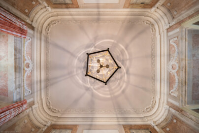 Schloss und Schlossgarten Schwetzingen - Garten - Badhaus - Von innen - Östliches Vorzimmer - Von unten - Zentraler Blick von unten auf die Decke; Verzierungen Wandabschluss zur Decke: ein durchgehender Perlstab, ein stehender Akanthusfries und ein glattes Gesims; Verzierungen am Rand der Decke: vier Mäanderfriese, an den Enden stuckierte Scheiben, in den Ecken Akanthusranken, schleifenartig von einer Rosette zusammengehalten; links das Fenster, rechts die Tür zum Ovalsaal (Gesamter Bau: Länge x Breite ca. 18 x 14 Meter, Höhe ca. 10 Meter; Architekt: Nicolas de Pigage (1723-1796); Bauzeit: 1768-1772; Gesamtinstandsetzung innen und außen: 1999-2006) (aufgenommen im Juli 2026, am Nachmittag)