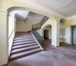 Schloss und Schlossgarten Schwetzingen - Garten - Gesandtenhaus (ehemaliges Prinzenhaus) / Amtsgericht - Von Innen - Treppenhaus / Erdgeschoss - Von Nordost - Blick vom Haupteingang in das Treppenhaus, auf die dreiläufige, zweimal abgewinkelte Sandsteintreppe mit zwei Zwischenpodesten sowie auf das schmiedeeiserne, verzierte Eisengeländer mit den verschlungenen Monogrammen "CP" für Kurfürst Carl Philipp (1661-1742, reg. 1716-1742) (aufgenommen im August 2026, am Nachmittag)