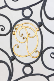 Schloss und Schlossgarten Schwetzingen - Garten - Gesandtenhaus (ehemaliges Prinzenhaus) / Amtsgericht - Von Innen - Treppenhaus / Erdgeschoss - Von Norden - Blick auf das verschlungene Monogramm mit den Initialien "CP" von Kurfürst Carl Philipp (1661-1742, reg. 1716-1742) am schmiedeeisernen, verzierten Eisengeländer des mittleren Laufs der dreiläufigen, zweimal abgewinkelten Sandsteintreppe mit zwei Zwischenpodesten (aufgenommen im August 2026, am späten Nachmittag)
