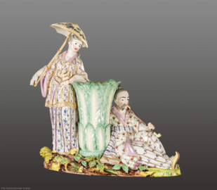Schloss und Schlossgarten Schwetzingen - Garten - Badhaus - Von innen - Chinesisches Zimmer - Figurengruppe aus Porzellan, Kamingesims, rechte Seite - Stehende Chinesin mit Sonnenschirm neben einer großen, aus Blättern gebildeten Vase; rechts ein sitzender Chinese mit langer Pfeife; polychrom bemaltes und goldstaffiertes Porzellan (Modell: Franz Conrad Linck (1730–1793), Porzellanmanufaktur Frankenthal) (Gesamter Bau: Länge x Breite ca. 18 x 14 Meter, Höhe ca. 10 Meter; Architekt: Nicolas de Pigage (1723-1796); Bauzeit: 1768-1772; Gesamtinstandsetzung innen und außen: 1999-2006) (aufgenommen im September 2026, am frühen Nachmittag)