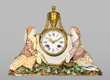 Schloss und Schlossgarten Schwetzingen - Garten - Badhaus - Von innen - Chinesisches Zimmer - Kaminuhr mit Figurengruppe aus Porzellan, Kamingesims, Mitte - Kaminuhr mit zwei Chinesenfrauen, polychrom bemalt und goldstaffiert, mit vergoldeter Metallmontierung (Neuausformung der Porzellanmanufaktur Nymphenburg, 2005 angekauft; Original: Modelleur und Uhrmacher dem Autor unbekannt, Datierung 1777 (Blaumarke CT mit 77) (Gesamter Bau: Länge x Breite ca. 18 x 14 Meter, Höhe ca. 10 Meter; Architekt: Nicolas de Pigage (1723-1796); Bauzeit: 1768-1772; Gesamtinstandsetzung innen und außen: 1999-2006) (aufgenommen im September 2026, am frühen Nachmittag)