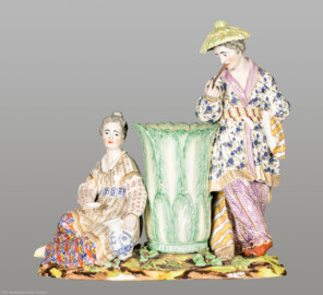 Schloss und Schlossgarten Schwetzingen - Garten - Badhaus - Von innen - Chinesisches Zimmer - Figurengruppe aus Porzellan, Kamingesims, linke Seite - Chinesenpaar mit Vase; links eine sitzende Chinesin, rechts ein stehender Chinese mit großem Sonnenhut, einen langen schmalen Gegenstand zum Mund führend; Porzellan mit polychromer Aufglasurmalerei und Vergoldung (Modell: Franz Conrad Linck (1730–1793), Porzellanmanufaktur Frankenthal, Datierung: evtl. 1779) (Gesamter Bau: Länge x Breite ca. 18 x 14 Meter, Höhe ca. 10 Meter; Architekt: Nicolas de Pigage (1723-1796); Bauzeit: 1768-1772; Gesamtinstandsetzung innen und außen: 1999-2006) (aufgenommen im September 2026, am frühen Nachmittag)