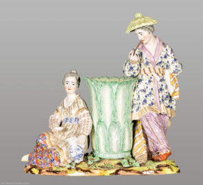 Schloss und Schlossgarten Schwetzingen - Garten - Badhaus - Von innen - Chinesisches Zimmer - Figurengruppe aus Porzellan, Kamingesims, linke Seite - Chinesenpaar mit Vase; links eine sitzende Chinesin, rechts ein stehender Chinese mit großem Sonnenhut, einen langen schmalen Gegenstand zum Mund führend; Porzellan mit polychromer Aufglasurmalerei und Vergoldung (Modell: Franz Conrad Linck (1730–1793), Porzellanmanufaktur Frankenthal, Datierung: evtl. 1779) (Gesamter Bau: Länge x Breite ca. 18 x 14 Meter, Höhe ca. 10 Meter; Architekt: Nicolas de Pigage (1723-1796); Bauzeit: 1768-1772; Gesamtinstandsetzung innen und außen: 1999-2006) (aufgenommen im September 2026, am frühen Nachmittag)