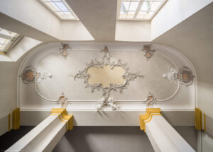 Schloss Bruchsal - Hauptbau / Corps de Logis - Von innen - Nordöstliche Dienertreppe - Zwischen zweitem und dritten Obergeschoss - Blick von der Treppe ins dritte Obergeschoss nach oben an die Decke mit den Stuckverzierungen (aufgenommen im September 2020, am frühen Nachmittag)