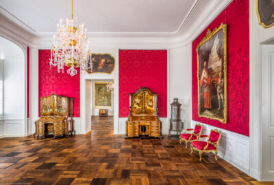 Schloss Bruchsal - Hauptbau / Corps de Logis - Von innen - Beletage - Rotes Zimmer - Von Süden - Blick nach Norden in das Rote Zimmer und den Durchgang zum Gelben Zimmer, links und rechts zwei Schreibschränke, vermutlich hergestellt in einer Mainzer oder Würzburger Werkstatt, oben die Supraporte "Der Sturz des Phaeton", gemalt von Januarius Zick, ganz rechts das Porträt von Franz Christoph von Hutten zum Stolzenberg, gemalt von Nikolaus Treu (aufgenommen im November 2020, am Nachmittag)