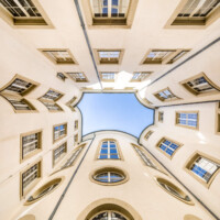 Schloss Bruchsal - Hauptbau / Corps de Logis - Von innen - Nördlicher Innenhof - Blick vom Boden des Innenhofs nach oben, unterhalb der Mitte die drei hohen nördlichen Bogenfenster des Kuppelsaals, darunter die drei Ovalfenster der Haupttreppe, darunter die Tür zur Grotte (unten ist Süden, oben Norden) (aufgenommen im März 2021, am frühen Nachmittag)