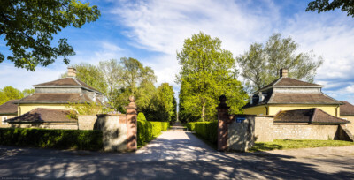 Schloss Bruchsal - Schlossgarten - Westlicher Zugang - Speierer Dragonerkaserne - Von Nordwesten - Blick von der Schwetzinger Straße auf die Allee nach Südosten Richtung Schloss; links und rechts die Häuser der ehemaligen Dragonerkaserne (aufgenommen im Mai 2021, am späten Nachmittag)