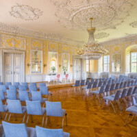 Schloss Bruchsal - Kammerflügel / Amtsgericht - Kammermusiksaal - Von Südost - Blick in den Raum, ausgestattet für standesamtliche Trauungen mit einem Tisch für das Brautpaar und den Standesbeamten (Saal ursprünglich gestaltet von Joachim Günther; heute genutzt für Trauungen und die Bruchsaler Schlosskonzerte) (aufgenommen im Juli 2021, am späten Vormittag)