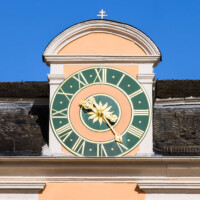 Schloss und Schlossgarten Schwetzingen - Schloss - Mittelbau - Gartenseite / Von Westen - Blick auf die zentrale Uhr am Dach; die Zeiger sind aus unbekannten Gründen vertauscht, der große Zeiger zeigt die Stunden, der kleine Zeiger die Minuten an (Mittelbau: Länge Westseite ca. 45 Meter, Breite Süd-/Nordseite ca. 38 Meter; Wiederaufbau / Erweiterung: 1698-1717; Architekten: Johann Adam Breunig, Simon Sarto) (aufgenommen im April 2023, am späten Nachmittag)