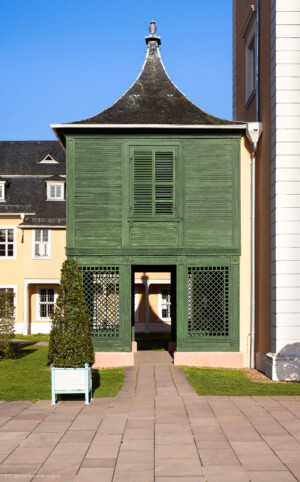 Schloss und Schlossgarten Schwetzingen - Schloss - Mittelbau - Gartenseite / Von Westen - Blick auf den Grünen Gartenpavillon (auch "Chinesischer Erker" genannt), ein hölzerner Anbau im Stil der Chinamode des 18. Jahrhunderts; im Obergeschoss befand sich das Arbeitszimmer von Carl Theodor (Hölzerner Anbau, Grundfläche 5 x 5 Meter, fertiggestellt 1780, zuletzt restauriert 2017, Architekt Nicolas de Pigage) (aufgenommen im April 2023, am späten Nachmittag)