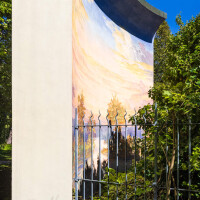 Schloss und Schlossgarten Schwetzingen - Garten - Badhausanlage - Perspektiv - Von Westen - Blick hinter der westlichen Umfassungsmauer der Badhausanlage nach Osten auf die gewölbte Wand mit der gemalten Landschaft des Perspektivs ("Das Ende der Welt"); Fresko ursprünglich erstellt von dem Mannheimer Theatermaler Truckenmüller nach einer Vorlage von Ferdinand Kobell (1740-1799) (Perspektiv: Abmessungen Länge x Breite x Höhe: Laubengang ca. 40 x 3,5 x 4,5 Meter, Bau ca. 16 x 4,5 bis 11 x 6,5 Meter, Bildwand ca. 9 x 1 x 7,5 Meter; Fertigstellung: 1775, Gesamtinstandsetzung: 1988-1991, Restaurierung Laubengang: 2022; Architekt: Nicolas de Pigage) (aufgenommen im September 2023, am frühen Nachmittag)
