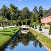 Schloss und Schlossgarten Schwetzingen - Garten - Orangeriegarten, nördlicher Kanal - Von Osten - Blick von der Nordostecke des Orangeriegartens nach Westen auf den Kanal mit der Brücke, rechts die Südfassade der Neuen Orangerie (aufgenommen im Oktober 2023, am späten Vormittag)
