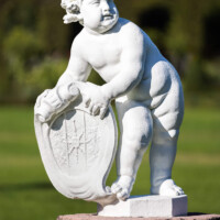Schloss und Schlossgarten Schwetzingen - Garten - Orangeriegarten, Südöstliche Ecke - Von Südosten - Blick auf einen Putto, ein Schild mit Wappen haltend (Bildhauer: Peter van den Branden (†1720) zugeschrieben; Datierung: unbekannt) (aufgenommen im Oktober 2023, am späten Vormittag)