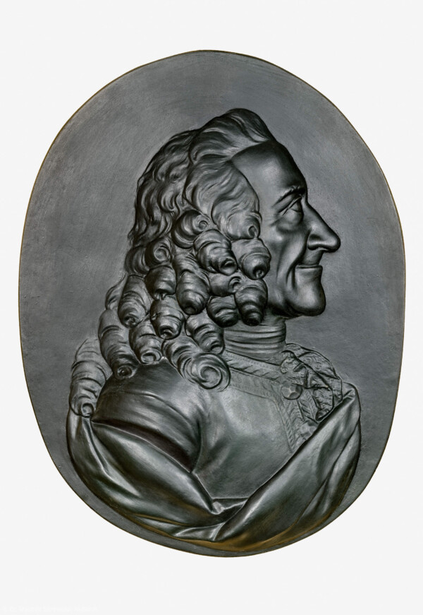 Schloss und Schlossgarten Schwetzingen - Schloss - Mittelbau - Von innen - 1. Obergeschoss - Appartment des Kurfürsten - Konferenzzimmer - Südwand, links der Mitte - Portrait-Relief von Voltaire (1694-1778) (Bildhauer: Franz Conrad Linck (1730-1793), Datierung: 1777; Material: Gips, schwarz gefärbt) (aufgenommen im Januar 2024, am Nachmittag)