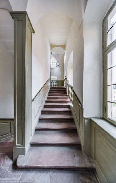 Schloss und Schlossgarten Schwetzingen - Schloss - Mittelbau - Von innen - Nördöstliches Treppenhaus - Von Westen - Blick vom Gang im 1. Obergeschoss nach Osten auf die Treppe und auf den Treppenabsatz zum 2. Obergeschoss (Mittelbau: Länge Westseite ca. 45 Meter, Breite Süd-/Nordseite ca. 38 Meter; Wiederaufbau / Erweiterung: 1698-1717; Architekt: Johann Adam Breunig) (aufgenommen im November 2025, am Nachmittag)