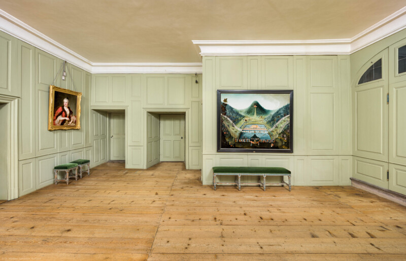 Schloss und Schlossgarten Schwetzingen - Schloss - Mittelbau - Von innen - 1. Obergeschoss - Appartment des Kurfürsten - Erstes Vorzimmer - Von Süden - Blick vom Kamin nach Norden in das erste Vorzimmer; die Tür ganz links führt in das zweite Vorzimmer, die Tür rechts davon führt auf den Gang der Empore der Schlosskapelle, die Tür rechts davon (sowie die nicht sichtbare Tür rechts daneben) führt in die Hofloge und die Tür ganz rechts führt in das Lakaienschlafzimmer (das gotische Turmzimmer); das Gemälde links zeigt Elisabeth Auguste von Pfalz-Sulzbach (1721-1794; Maler: Heinrich Carl Brandt (1724-1787); Datierung: um 1767), das Gemälde rechts zeigt eine sog. "eingestellte Jagd" unter Kurfürst Karl III. Philipp (1661-1742, reg. 1716-1742; Maler und Datierung: unbekannt) (aufgenommen im Dezember 2025, am Nachmittag)