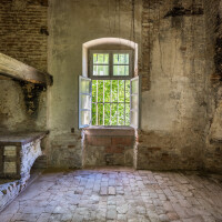 Schloss und Schlossgarten Schwetzingen - Garten - Badhausanlage - Badhausküche - Von innen - Küche - Von Norden - Blick vom nördlichen Fenster nach Süden in die Küche; links der Herdblock mit dem Schürloch, darüber der Ansatz der (ehemaligen) großen Kaminabzugshaube, rechts eine Wandnische und ganz rechts die Tür zur Rotunde (Gesamter Bau: Länge x Breite (winkelförmig) ca. 13 x 11 Meter, Höhe (über Rotunde) ca. 8 Meter; Raum: Länge x Breite x Höhe ca. 6 x 6 x 5,5 Meter; Architekt: Nicolas de Pigage (1723-1796); Bauzeit: 1768-1772, Dachinstandsetzung; 1983-1985, Instandsetzung: 2013-2015) (aufgenommen im April 2026, am späten Nachmittag)